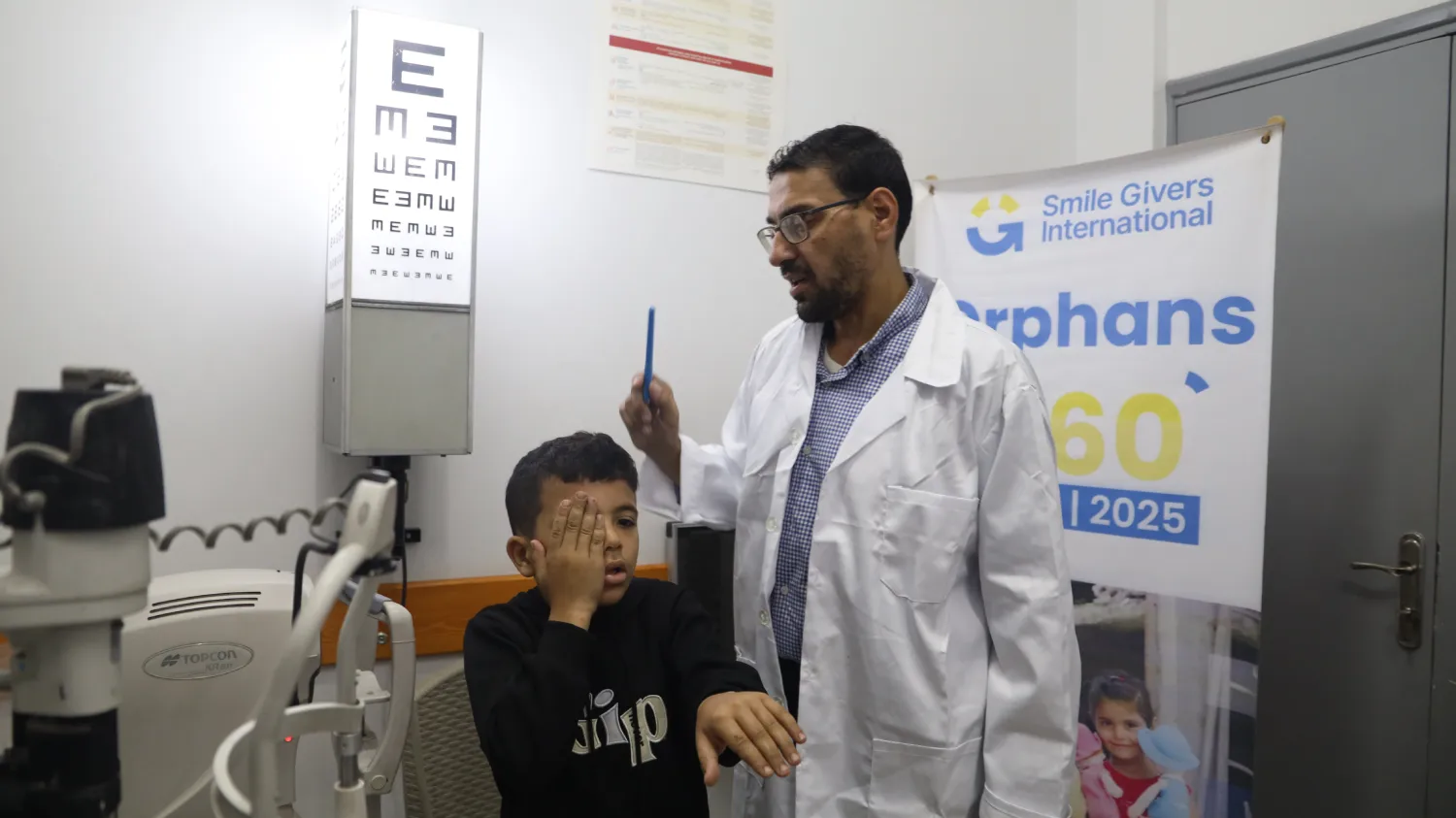 Orphan boy receiving eye exam from SGI doctor